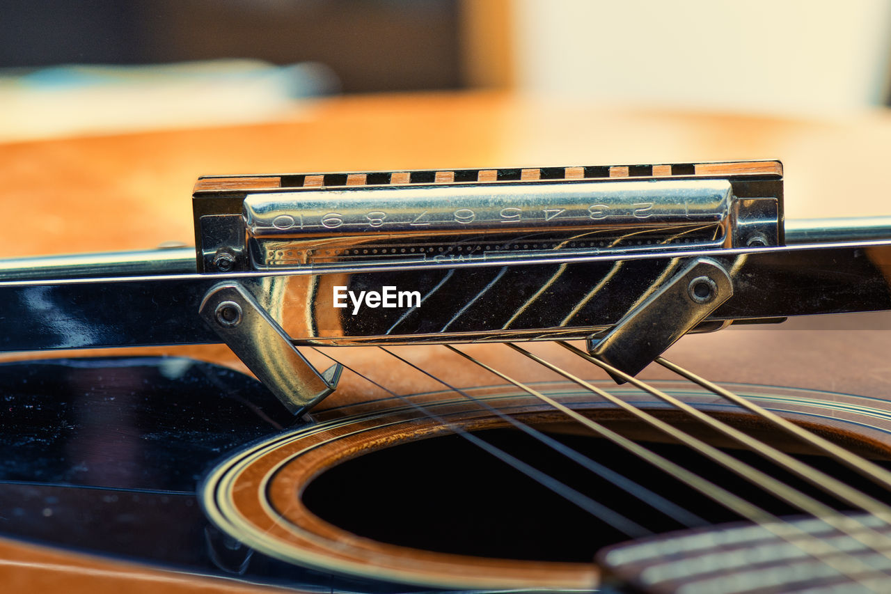 guitar, music, musical instrument, arts culture and entertainment, musical equipment, plucked string instruments, string instrument, acoustic guitar, indoors, bass guitar, close-up, no people, musical instrument string, selective focus, string, focus on foreground, still life, electric guitar