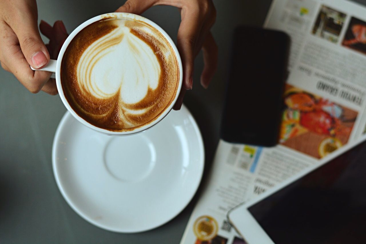 CLOSE-UP OF WOMAN HOLDING COFFEE CUP WITH CAPPUCCINO