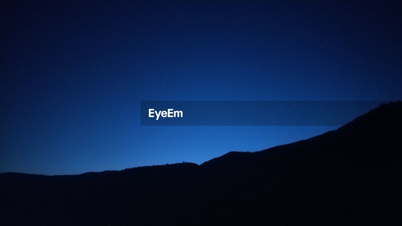 SCENIC VIEW OF SILHOUETTE MOUNTAIN AGAINST CLEAR BLUE SKY