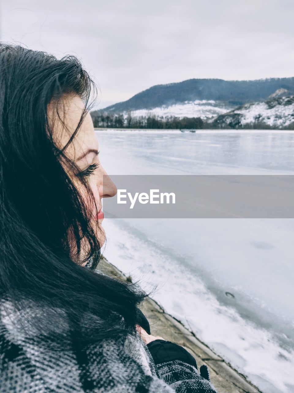 Woman at lakeshore during winter