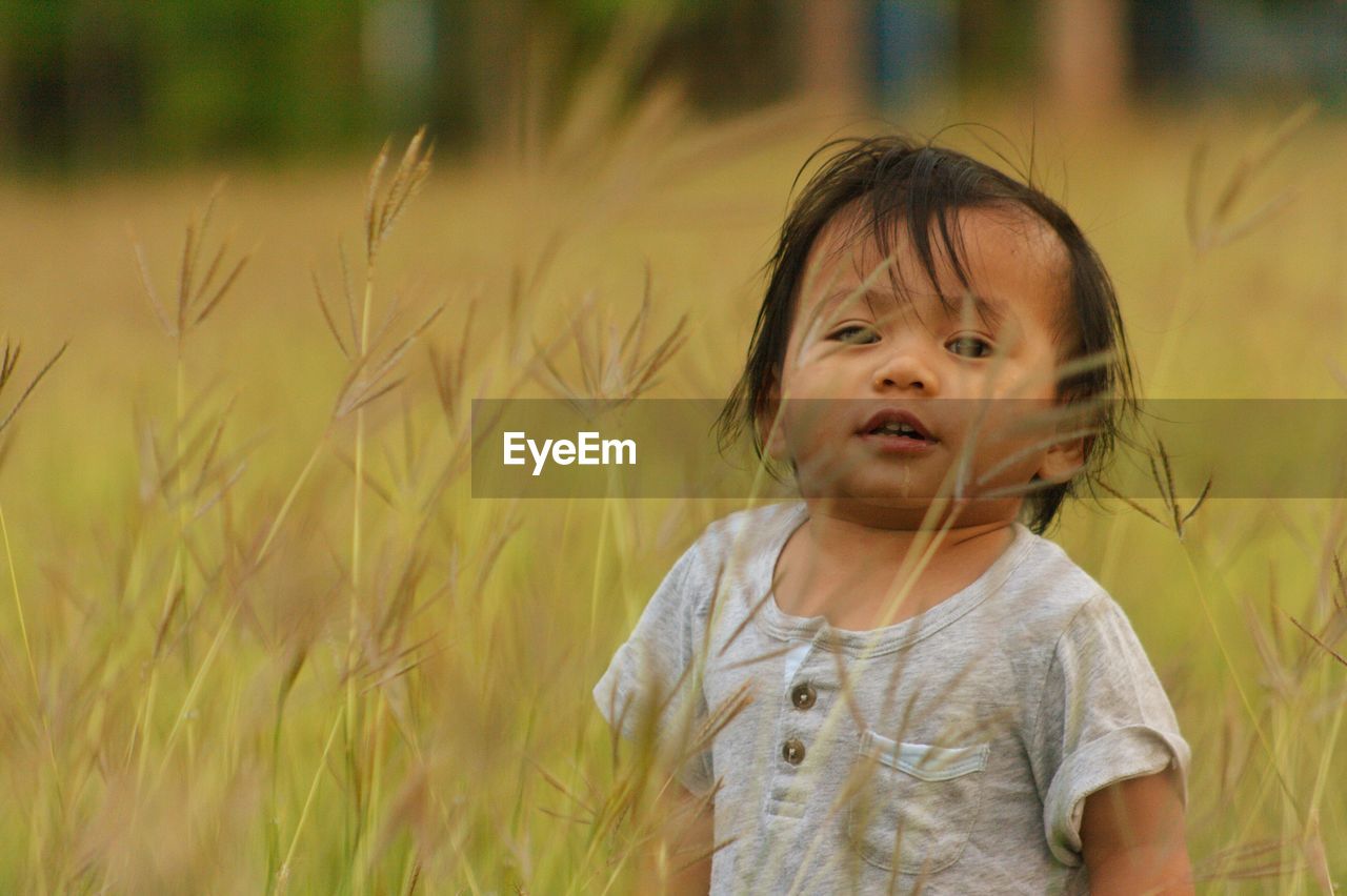 PORTRAIT OF CUTE BOY STANDING ON LAND