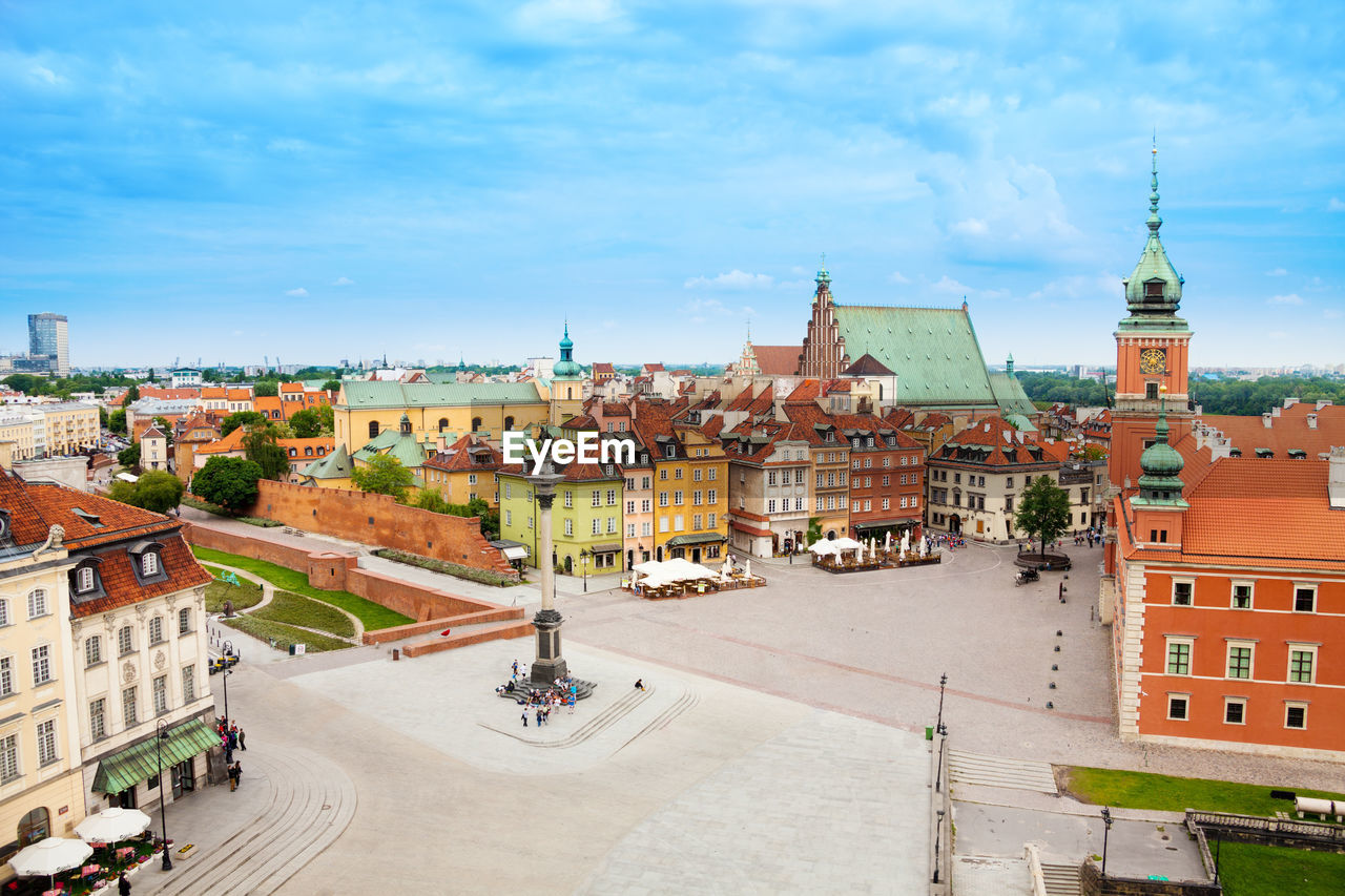 HIGH ANGLE VIEW OF BUILDINGS IN CITY AGAINST CLOUDY SKY