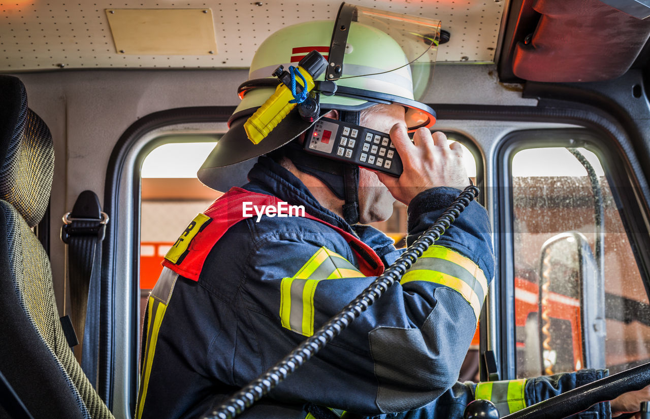 Firefighter taking emergency call in firetruck