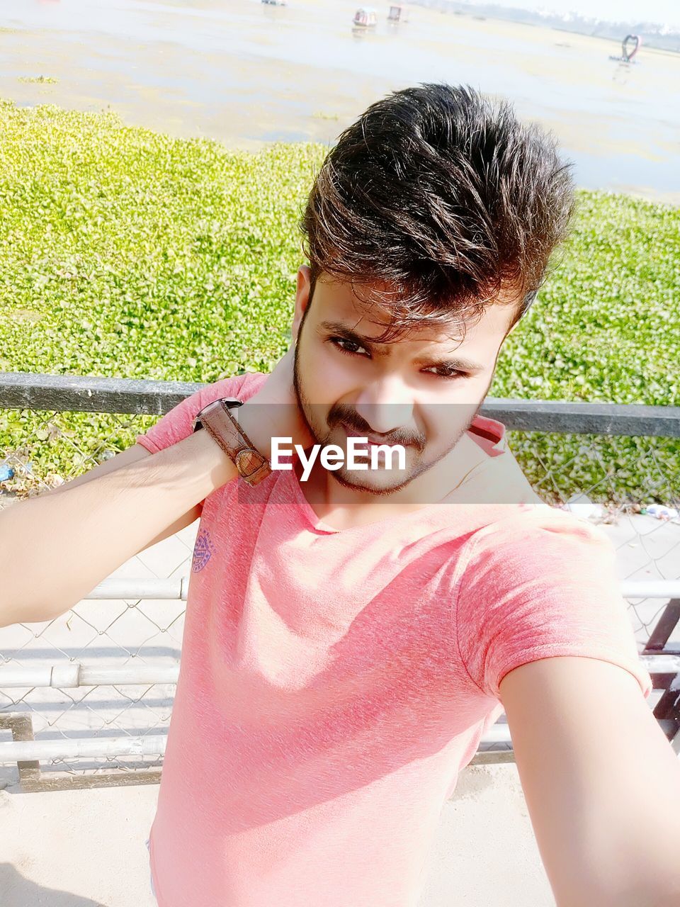 High angle view of handsome man standing by fence