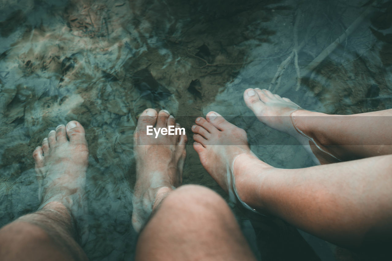 Low section of man and woman in water