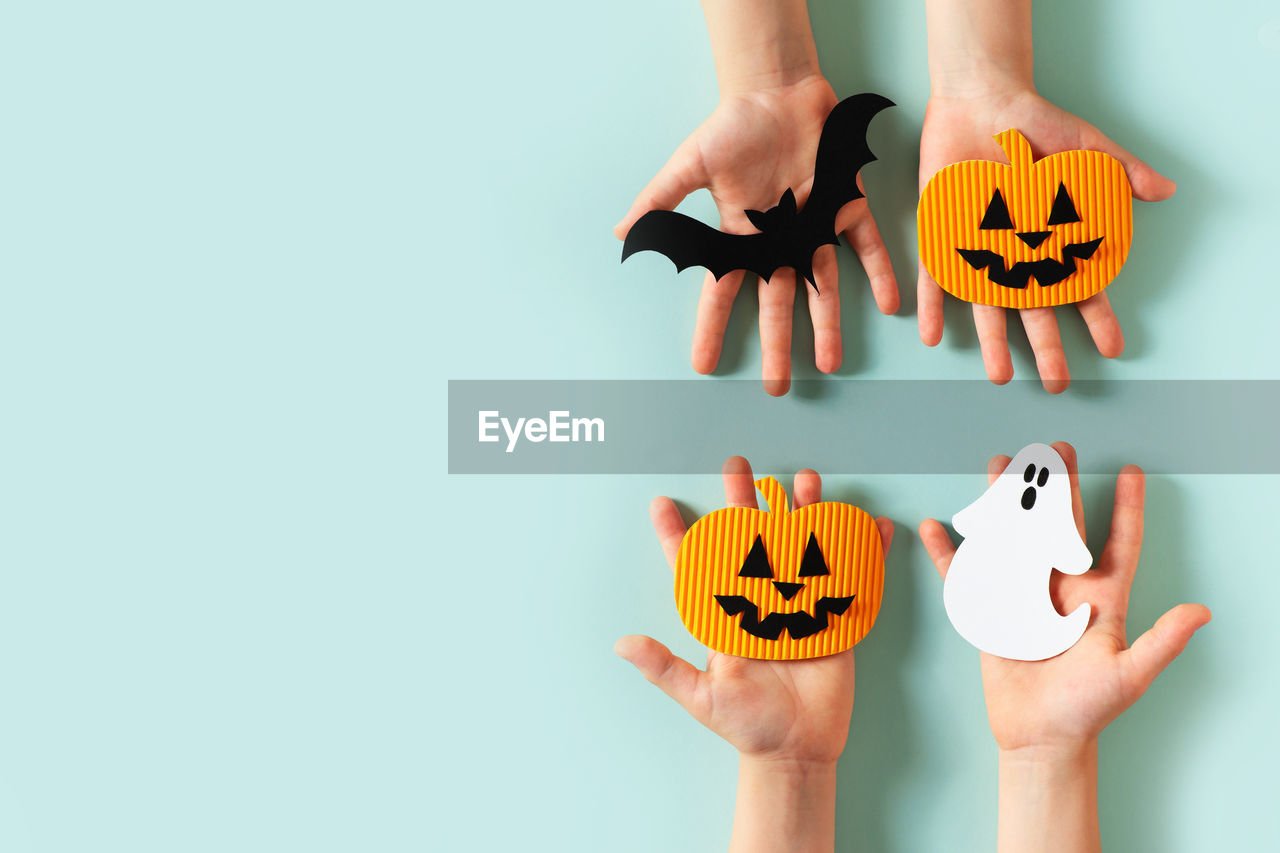 Kids hands with paper craft halloween toys