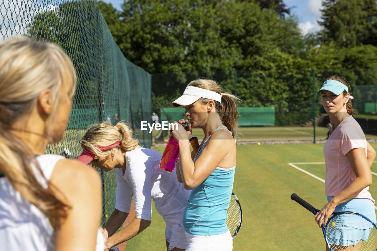 Mature women at tennis club taking a break from playing