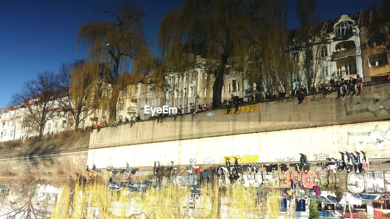 Reflection of people by buildings on calm canal