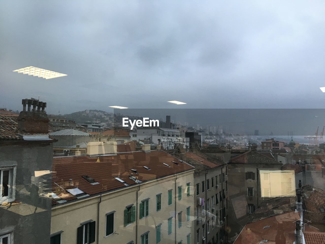 VIEW OF CITYSCAPE AGAINST CLOUDY SKY