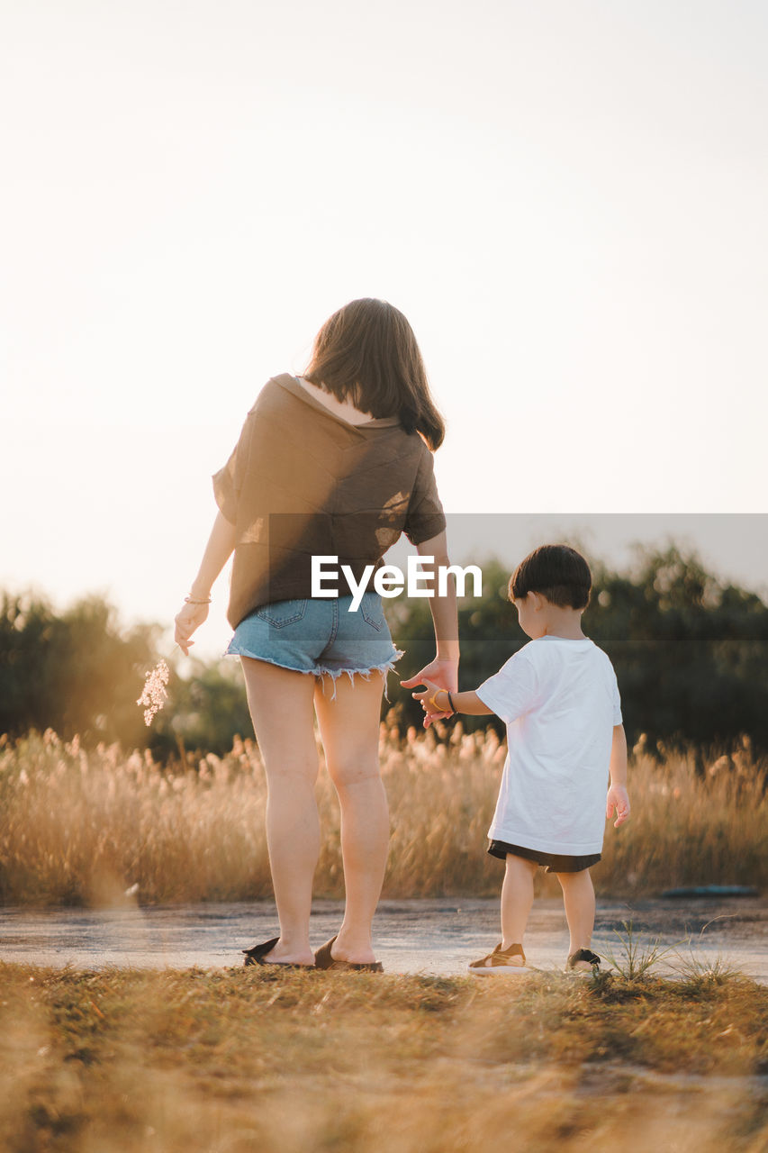 Parent mother holding child hand on the field