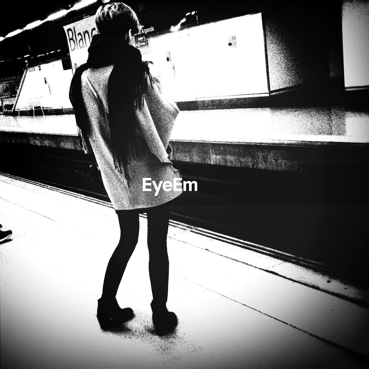 YOUNG WOMAN STANDING IN THE DARK