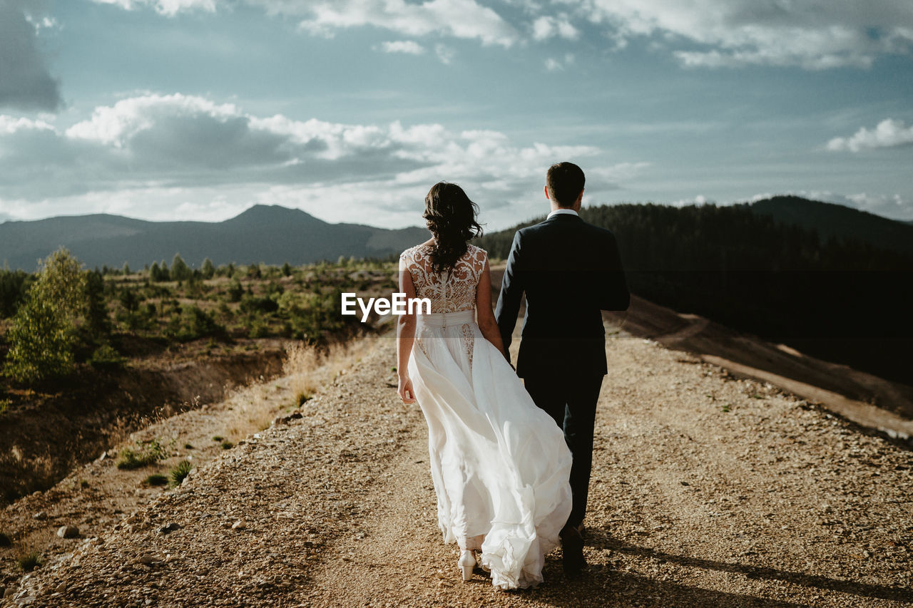 REAR VIEW OF COUPLE WALKING ON ZEBRA