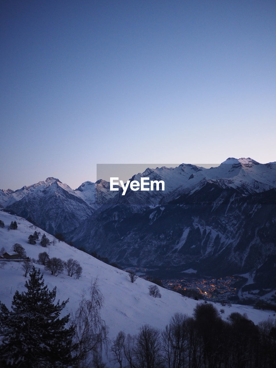 Scenic view of snowcapped mountains against clear blue sky