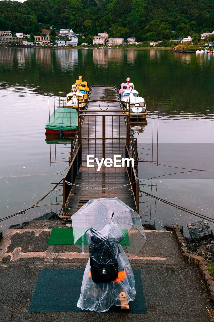 REAR VIEW OF MAN AND WOMAN IN BOAT ON LAKE