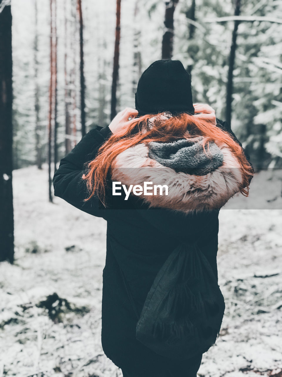 Rear view of woman on snow covered field