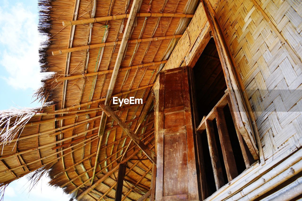 LOW ANGLE VIEW OF HOUSE ROOF AGAINST BUILDING