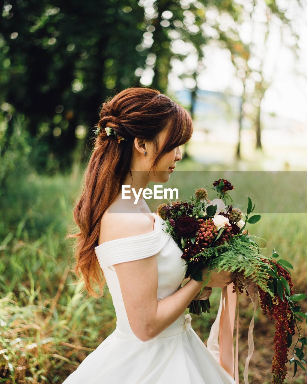 Young woman standing by flowering plants