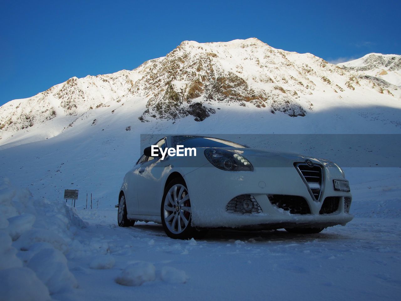 CAR ON SNOW COVERED LANDSCAPE
