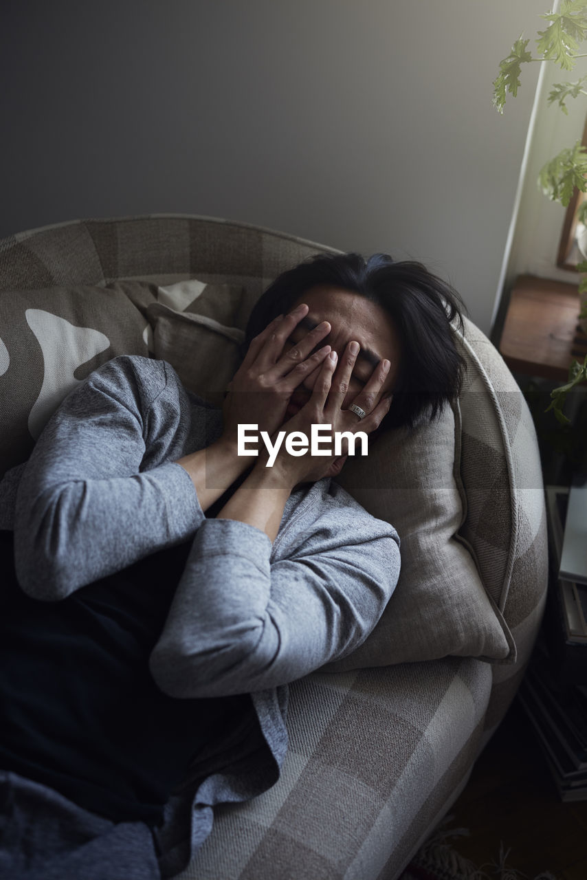 Man facing depression with hands covering his face