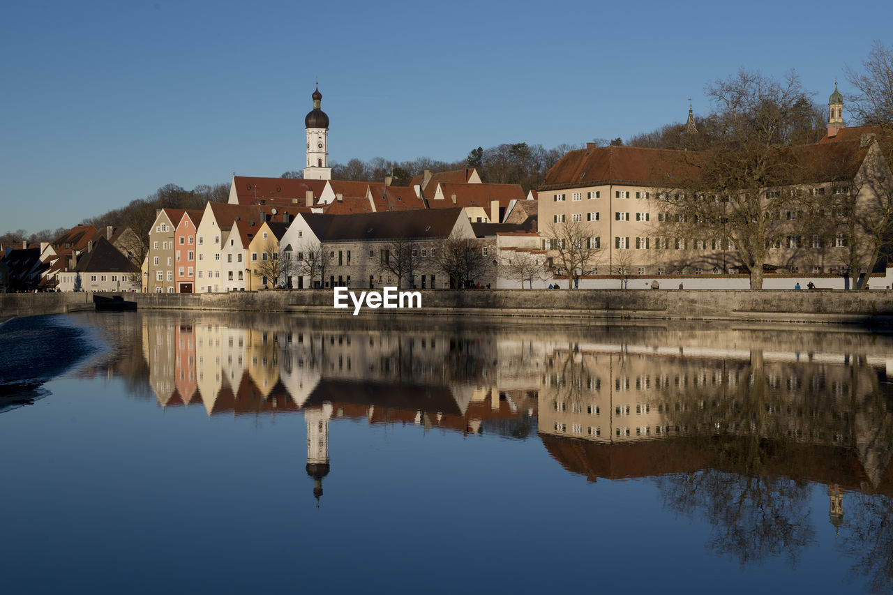 REFLECTION OF BUILDING IN LAKE AGAINST SKY