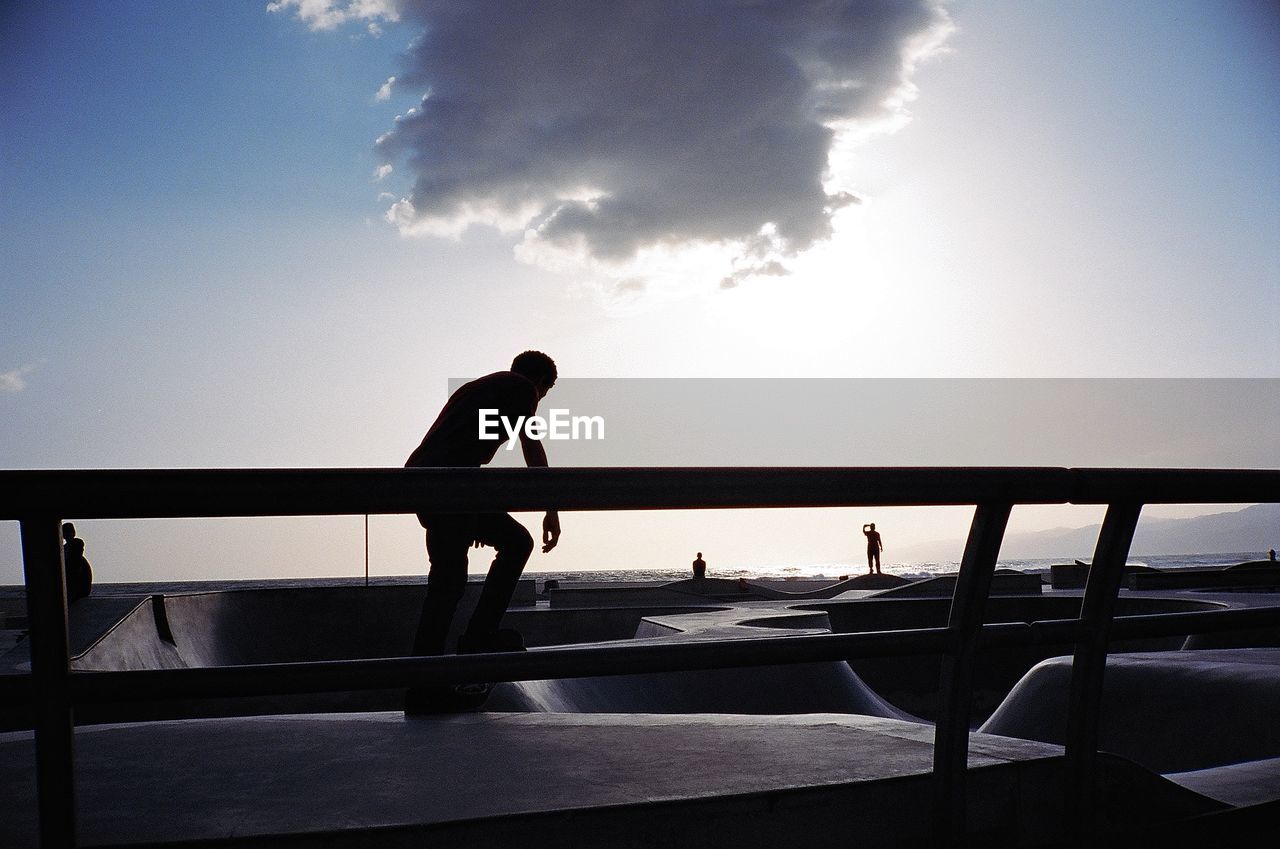 Silhouette man in boat against sky