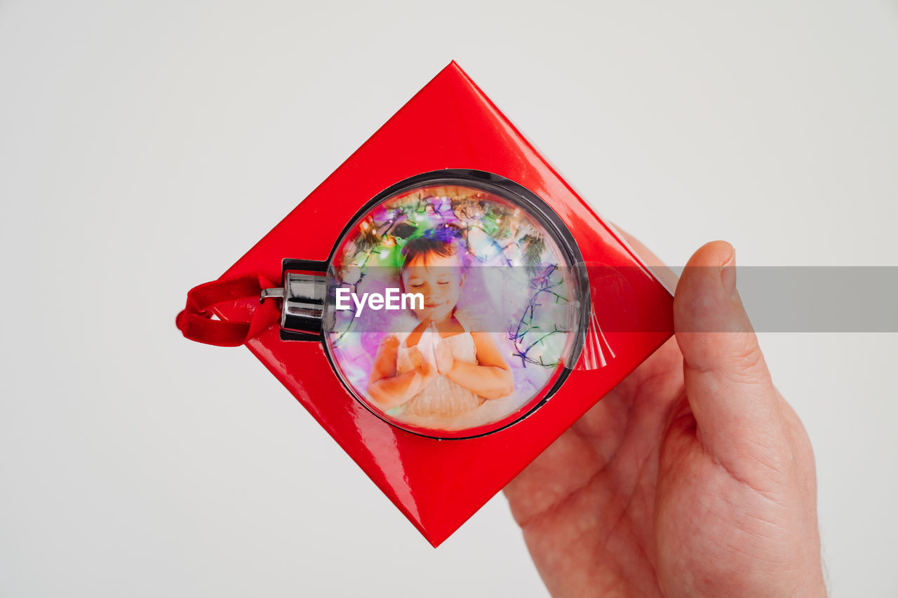 DIGITAL COMPOSITE IMAGE OF HAND HOLDING EYEGLASSES