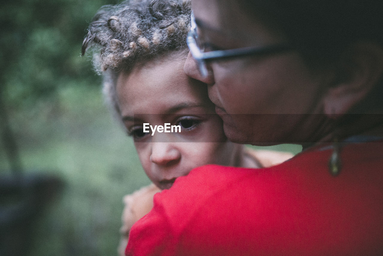Mother with thoughtful son at yard