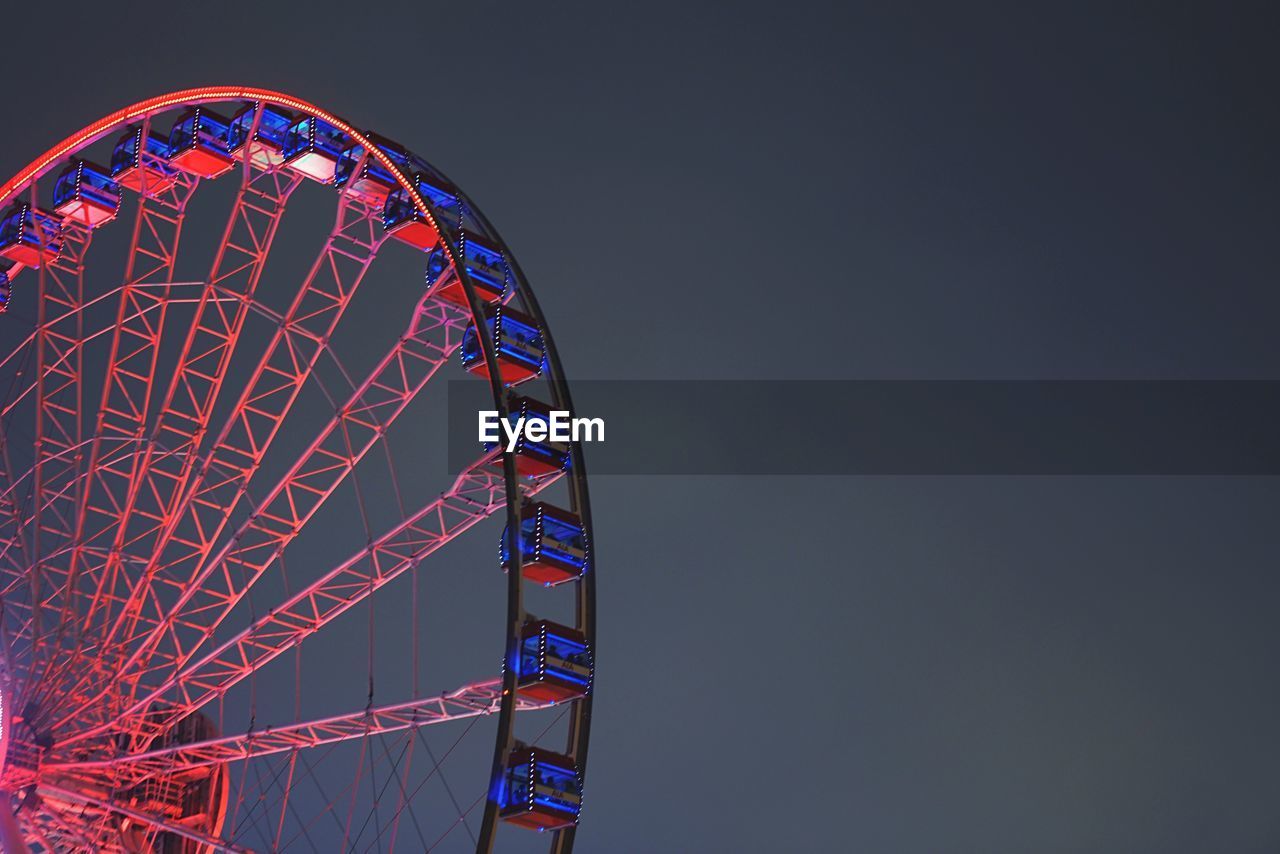 Low angle view of ferris wheel against sky at night