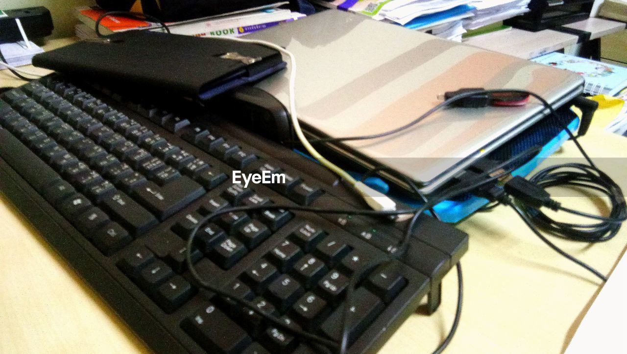 HIGH ANGLE VIEW OF LAPTOP KEYBOARD ON TABLE AT HOME