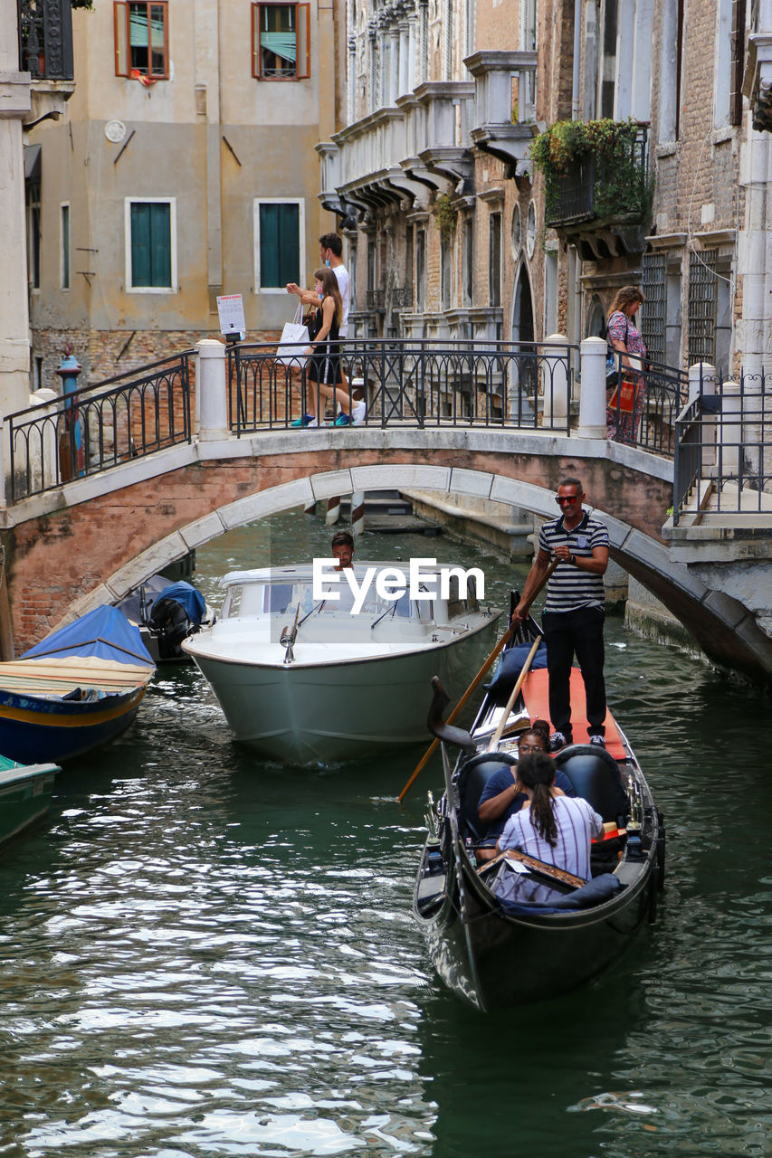 PEOPLE IN BOAT AGAINST CANAL