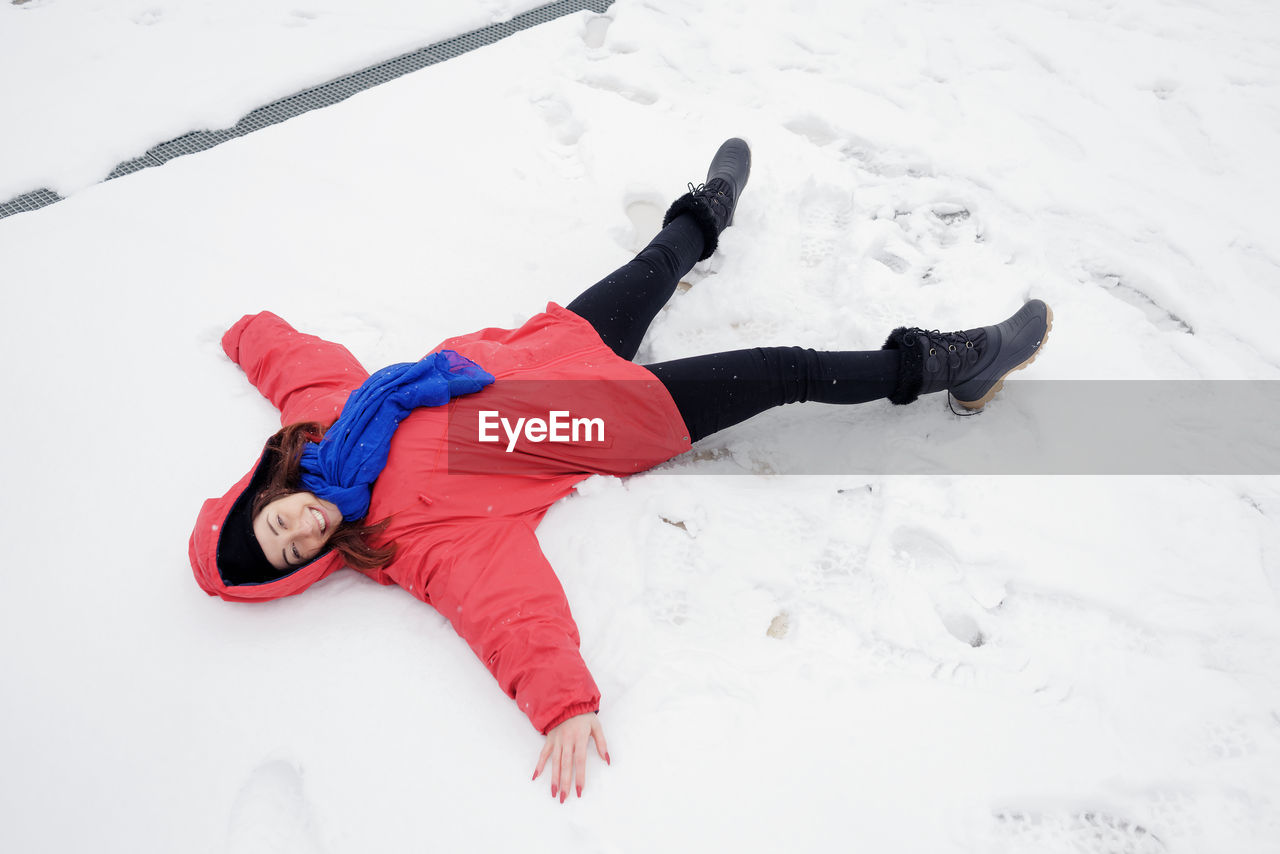 High angle view of woman making snow angel on land