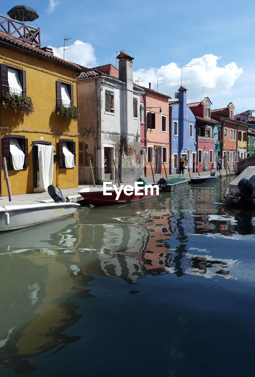 BOATS MOORED IN CANAL AMIDST BUILDINGS IN CITY