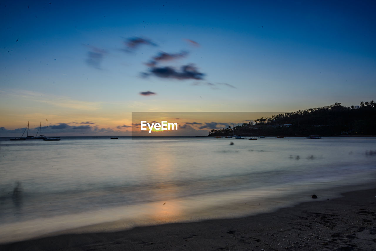 sky, water, sea, land, beach, scenics - nature, sunset, reflection, beauty in nature, nature, ocean, cloud, tranquility, wave, dawn, horizon, evening, tranquil scene, shore, coast, environment, body of water, travel destinations, blue, no people, landscape, sand, sunlight, outdoors, travel, idyllic, seascape, coastline, sun, dramatic sky, motion, holiday