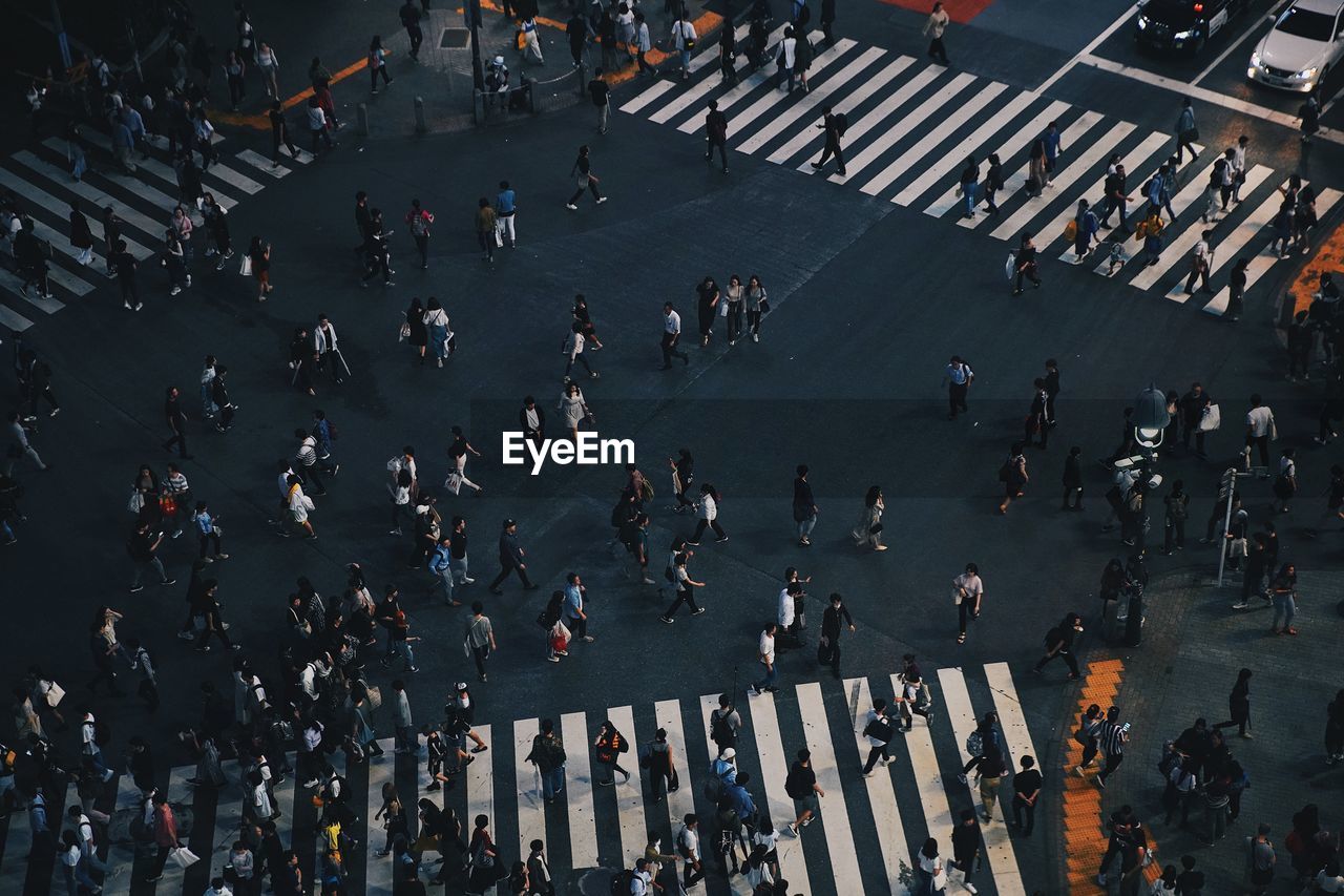 HIGH ANGLE VIEW OF PEOPLE WALKING ON ROAD IN CITY