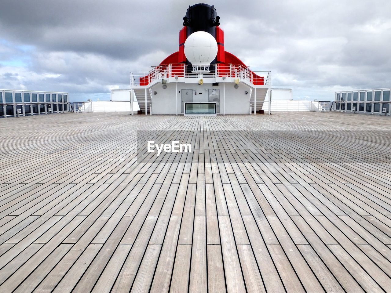 Low angle view of boat deck against cloudy sky