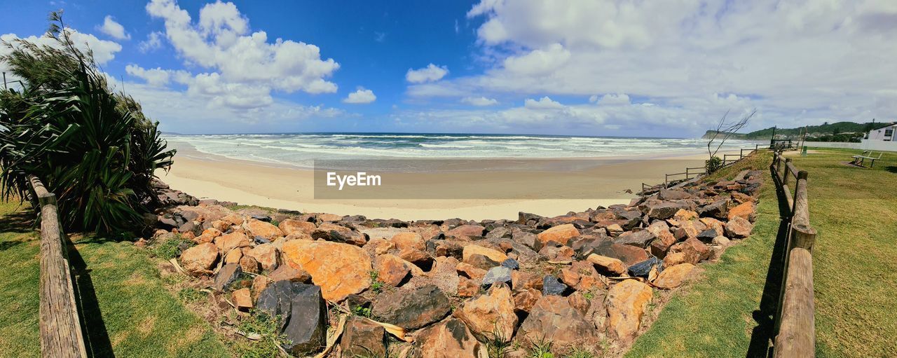 land, water, sea, sky, beach, nature, scenics - nature, cloud, coast, vacation, panoramic, beauty in nature, shore, landscape, rock, environment, travel destinations, plant, travel, tranquility, tree, tranquil scene, coastline, body of water, horizon over water, day, no people, horizon, sand, tourism, outdoors, terrain, holiday, tropical climate, ocean, cliff, trip, sunlight, blue, non-urban scene, idyllic, grass