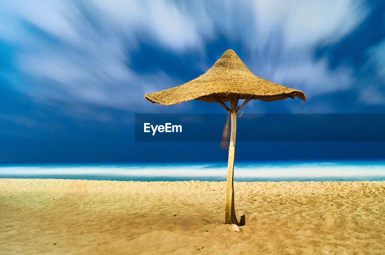 Umbrella on beach against sky