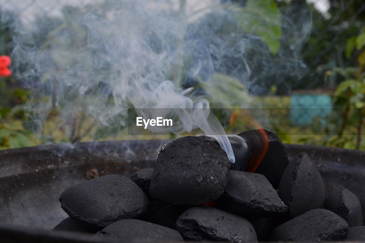 Close-up of burning coals emitting smoke