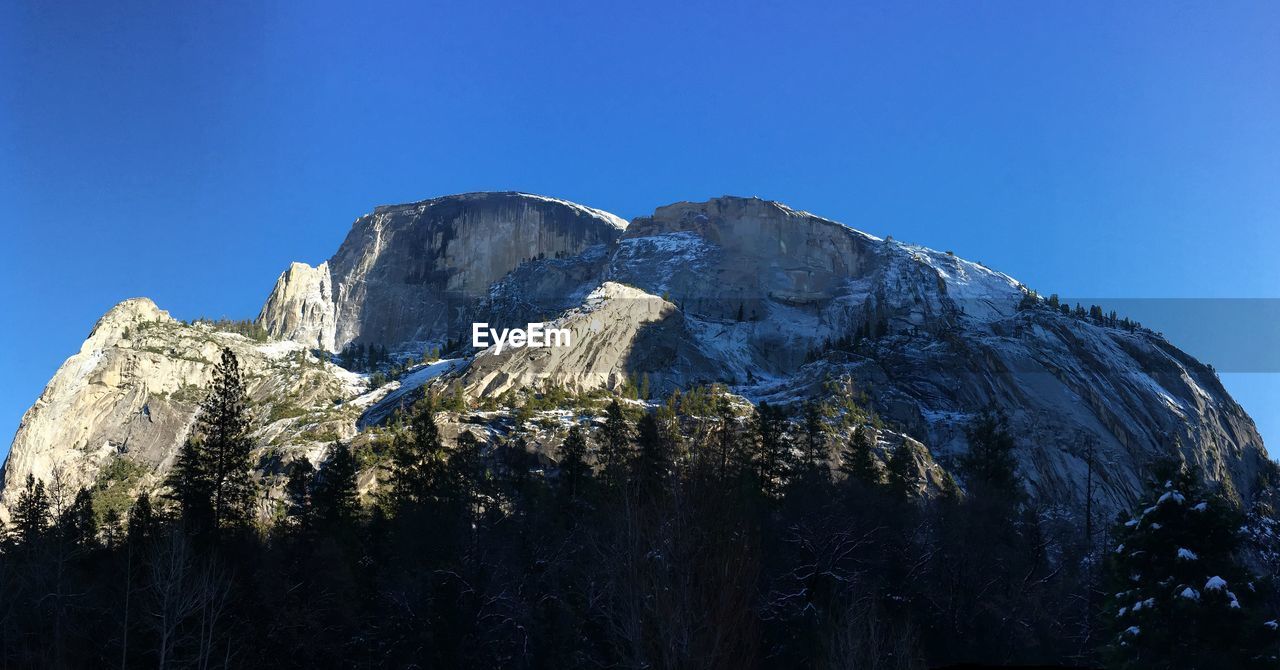 Scenic view of rocky mountain against clear blue sky