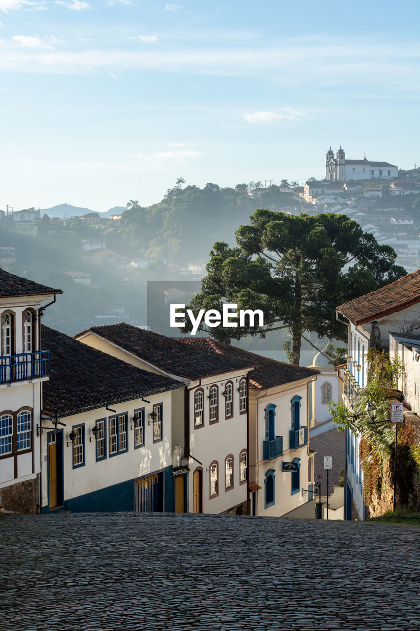 Houses by sea against sky in city