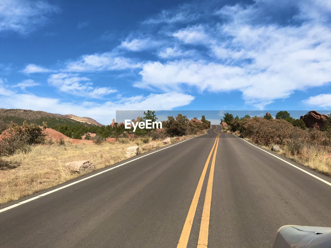 EMPTY ROAD ALONG LANDSCAPE AND AGAINST SKY