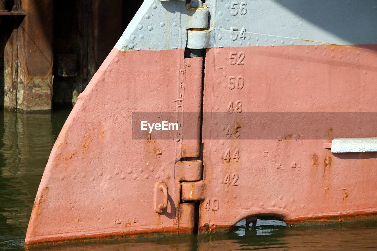 CLOSE-UP OF OLD WOODEN WALL BY CANAL