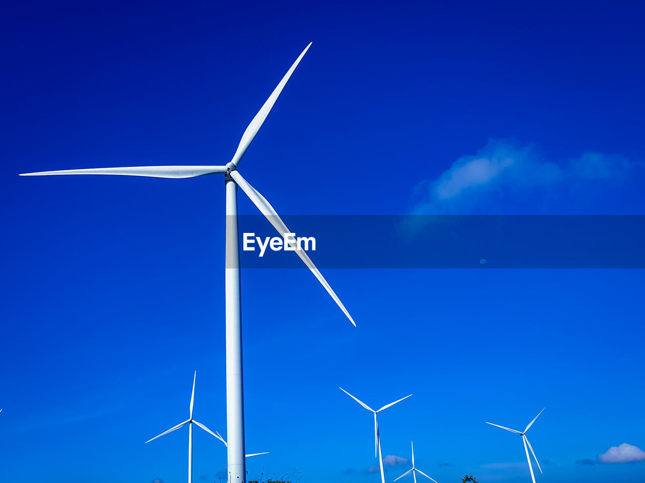 Low angle view of windmill against blue sky