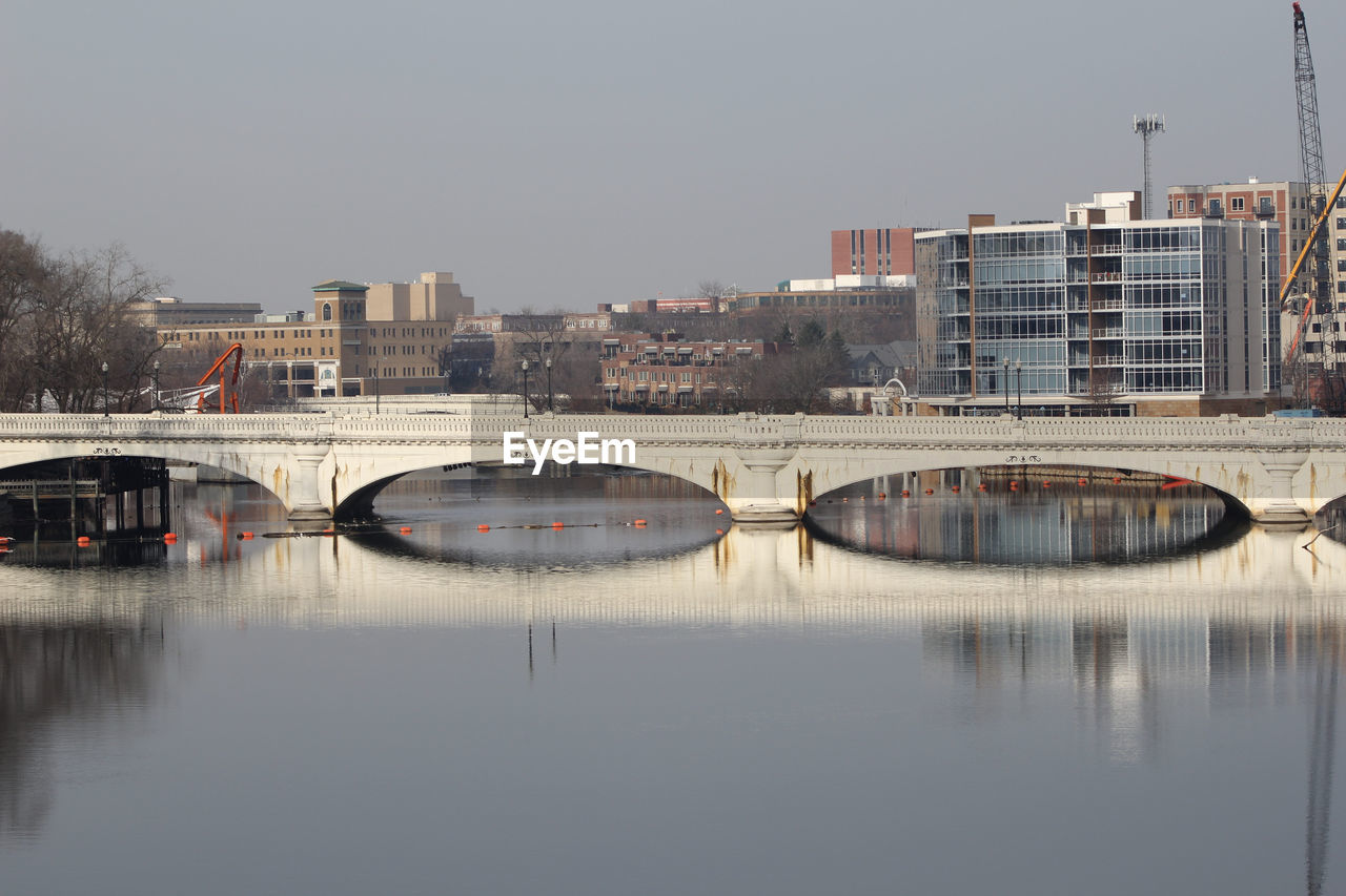 BRIDGE OVER RIVER AGAINST BUILDINGS IN CITY