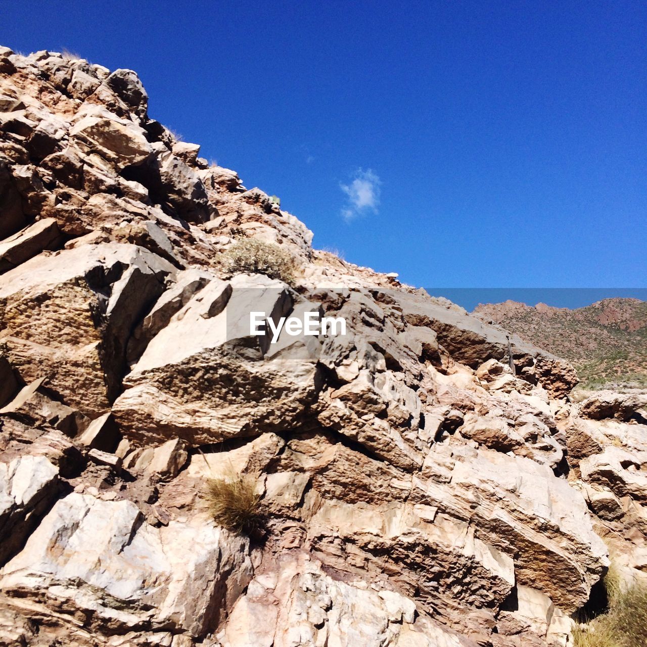 Low angle view of mountain against blue sky