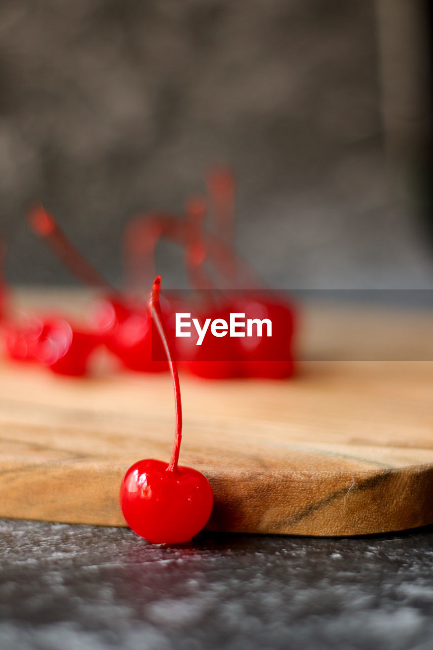 CLOSE-UP OF RED CHRISTMAS DECORATION ON TABLE