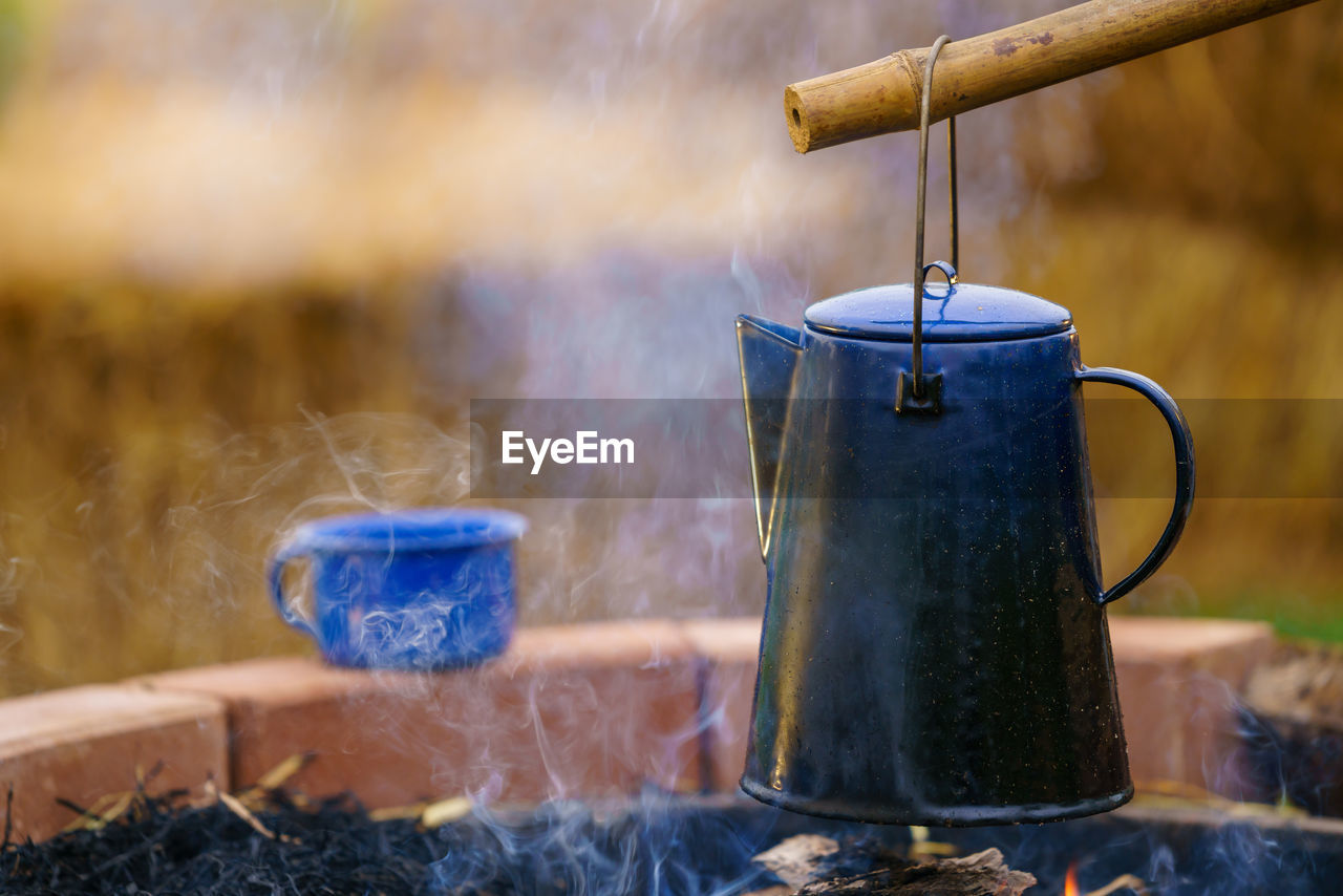 blue, morning, heat, food and drink, nature, kitchen utensil, steam, household equipment, smoke, no people, food, iron, kettle, container, day, tea, focus on foreground, metal, close-up, outdoors, drink, hot drink, cooking pan, plant, water, burning, wood, still life photography