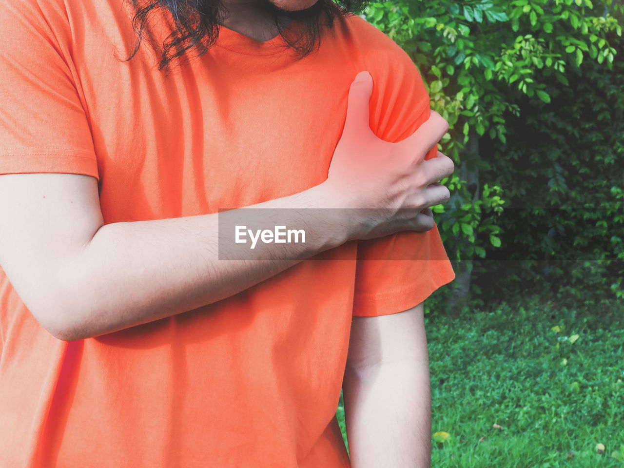 MIDSECTION OF WOMAN STANDING BY FIELD