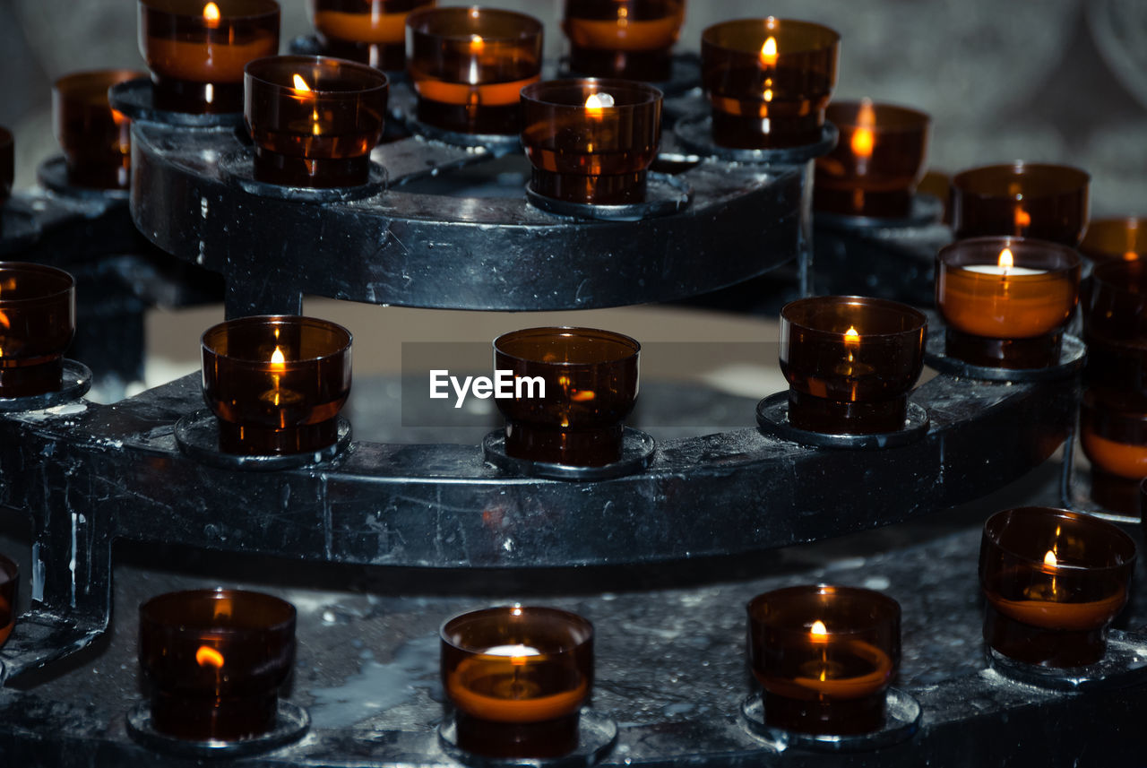 Close-up of lit tea light candles at altar in church
