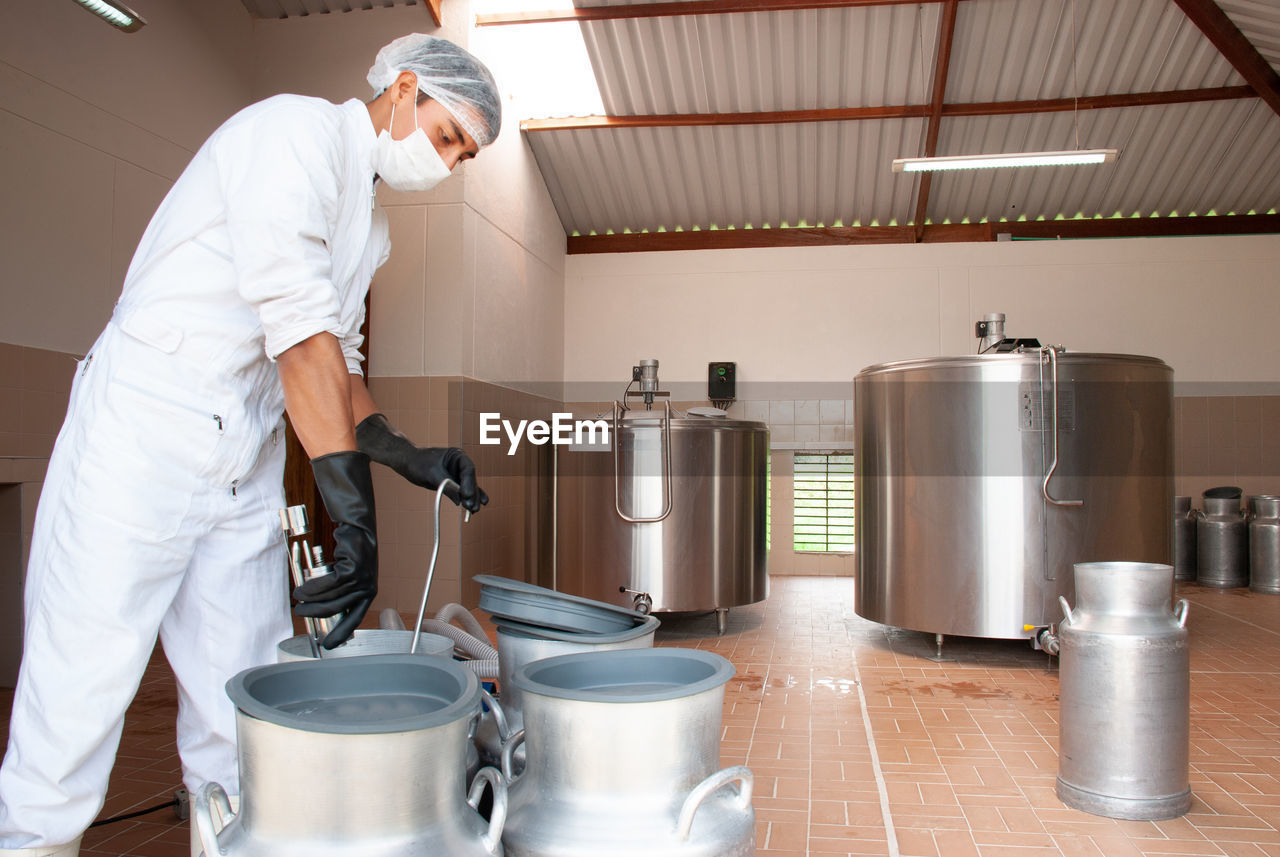 SIDE VIEW OF MAN PREPARING FOOD AT KITCHEN